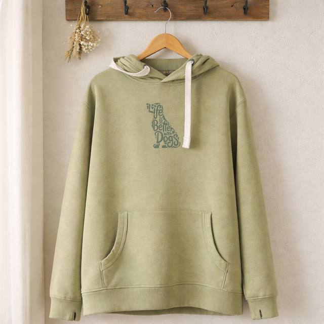 Green hoodie with text design on a wooden hanger against a beige wall.