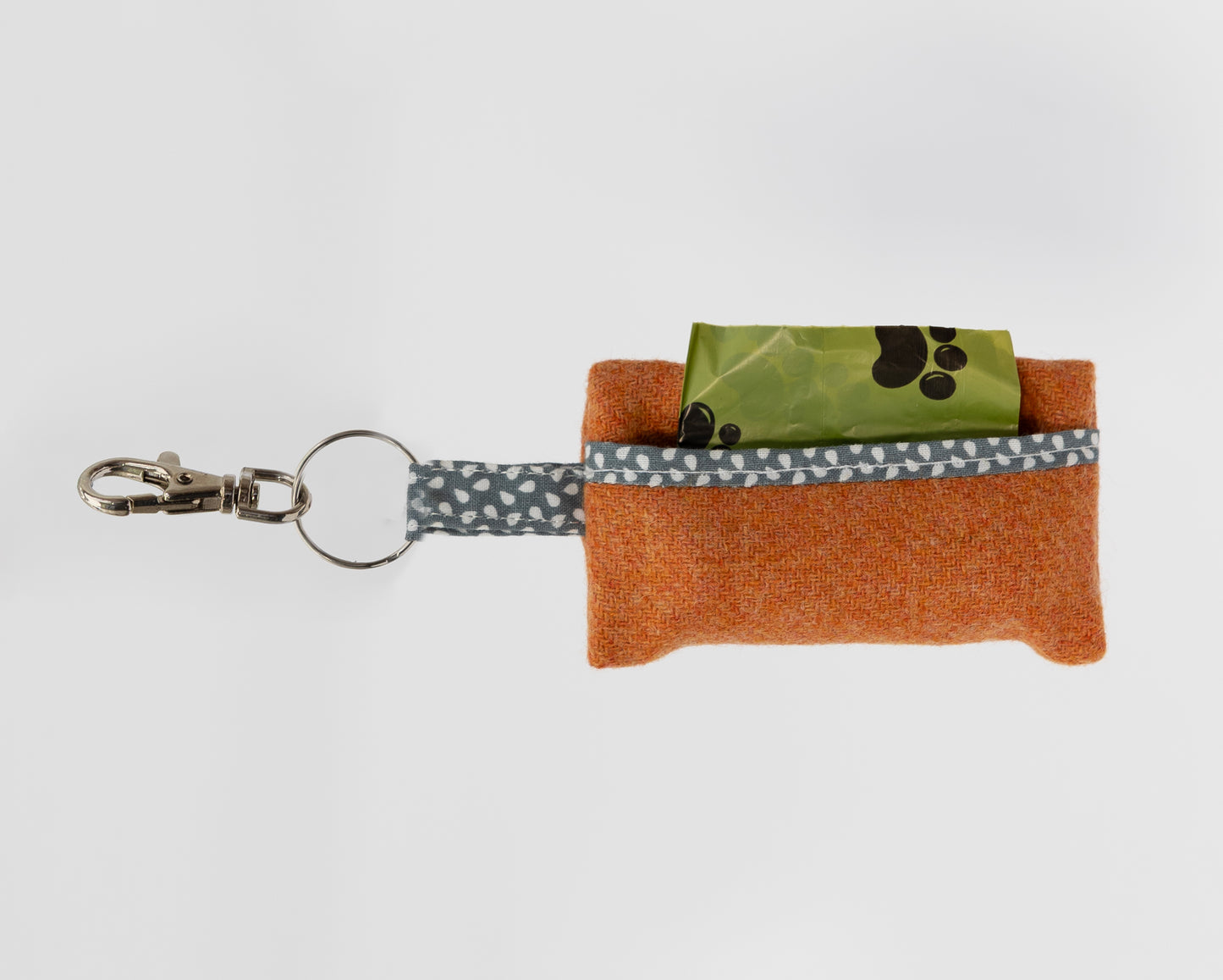 Small orange pouch with a keychain and gray strap on a white background