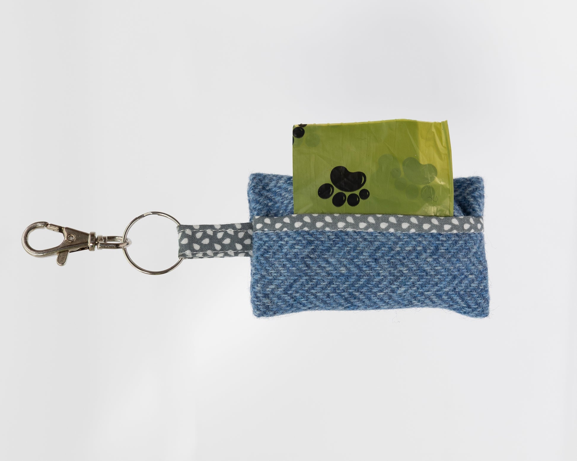 Blue fabric pouch with a key ring and green card on a white background