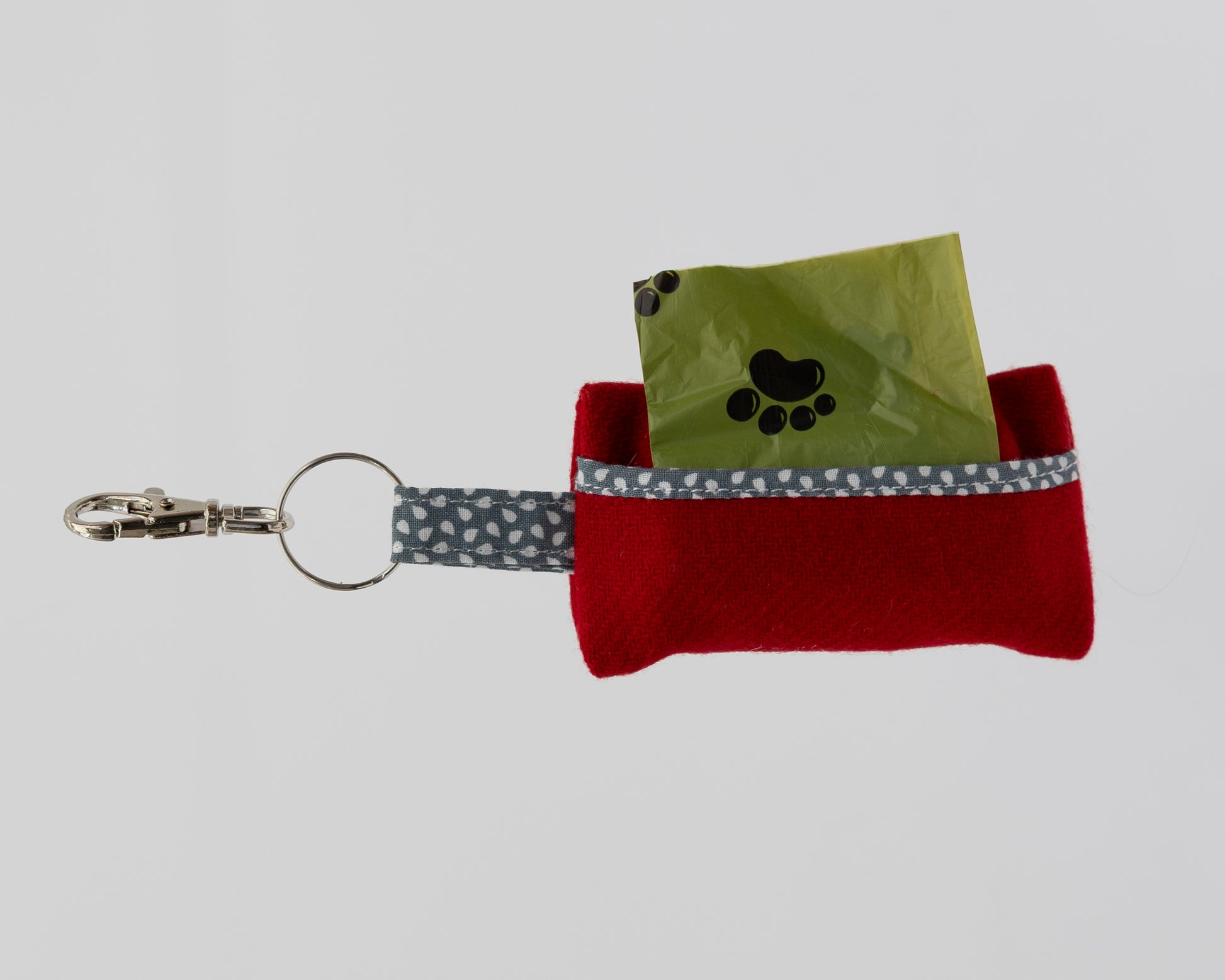 Red keychain pouch with a paw print design on a gray background