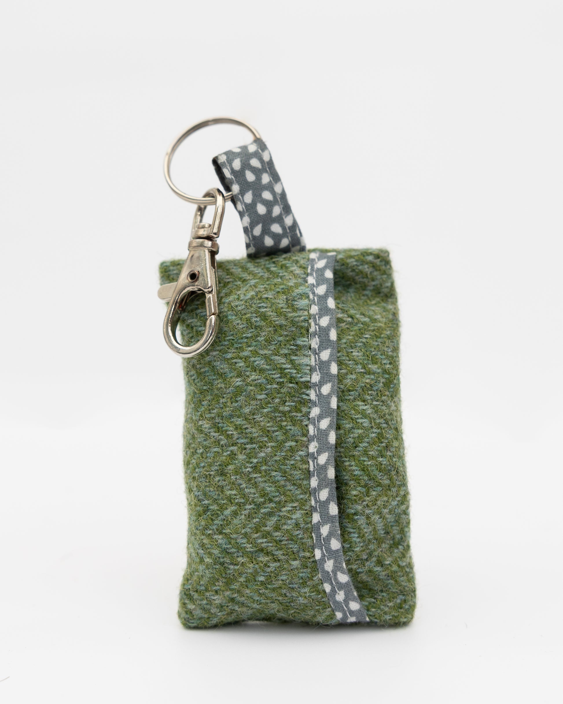 Green fabric keychain pouch with a gray strap on a white background