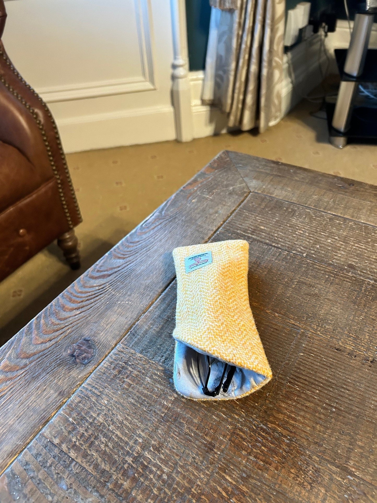 yellow harris tweed glasses case on a wooden table